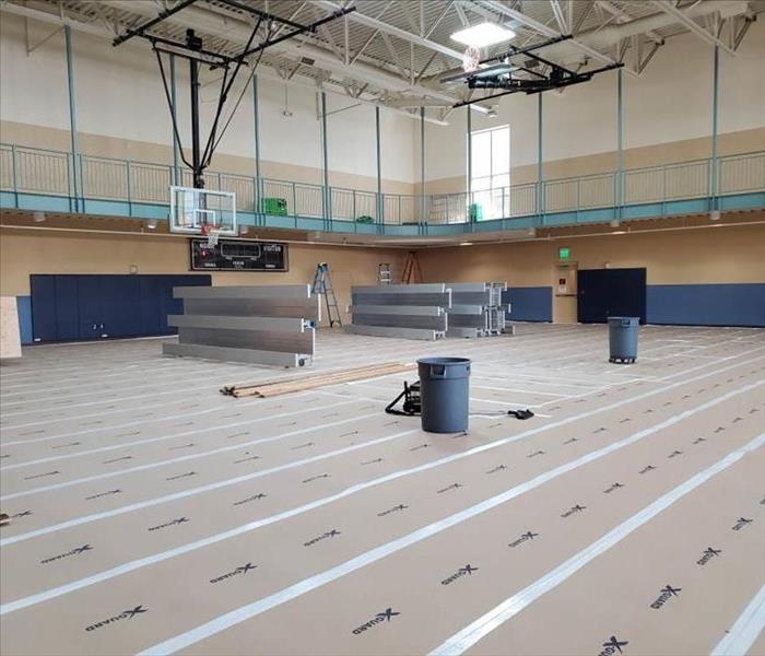 protective covering laid on gym wood flooring for the restoration team to provide fire damage restoration to facility