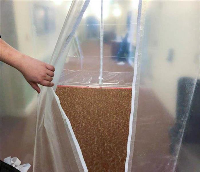 Employee holding open a mold containment system