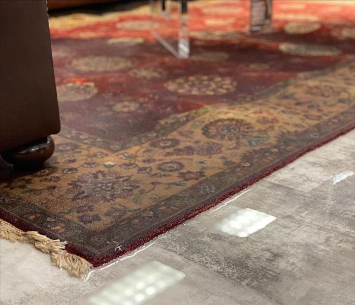 wet rug on tip of tile flooring with standing water surounding it